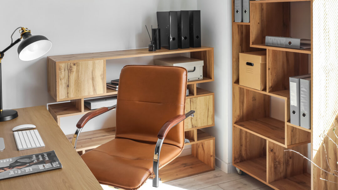 Interior of light office with desk, chair and shelving unit